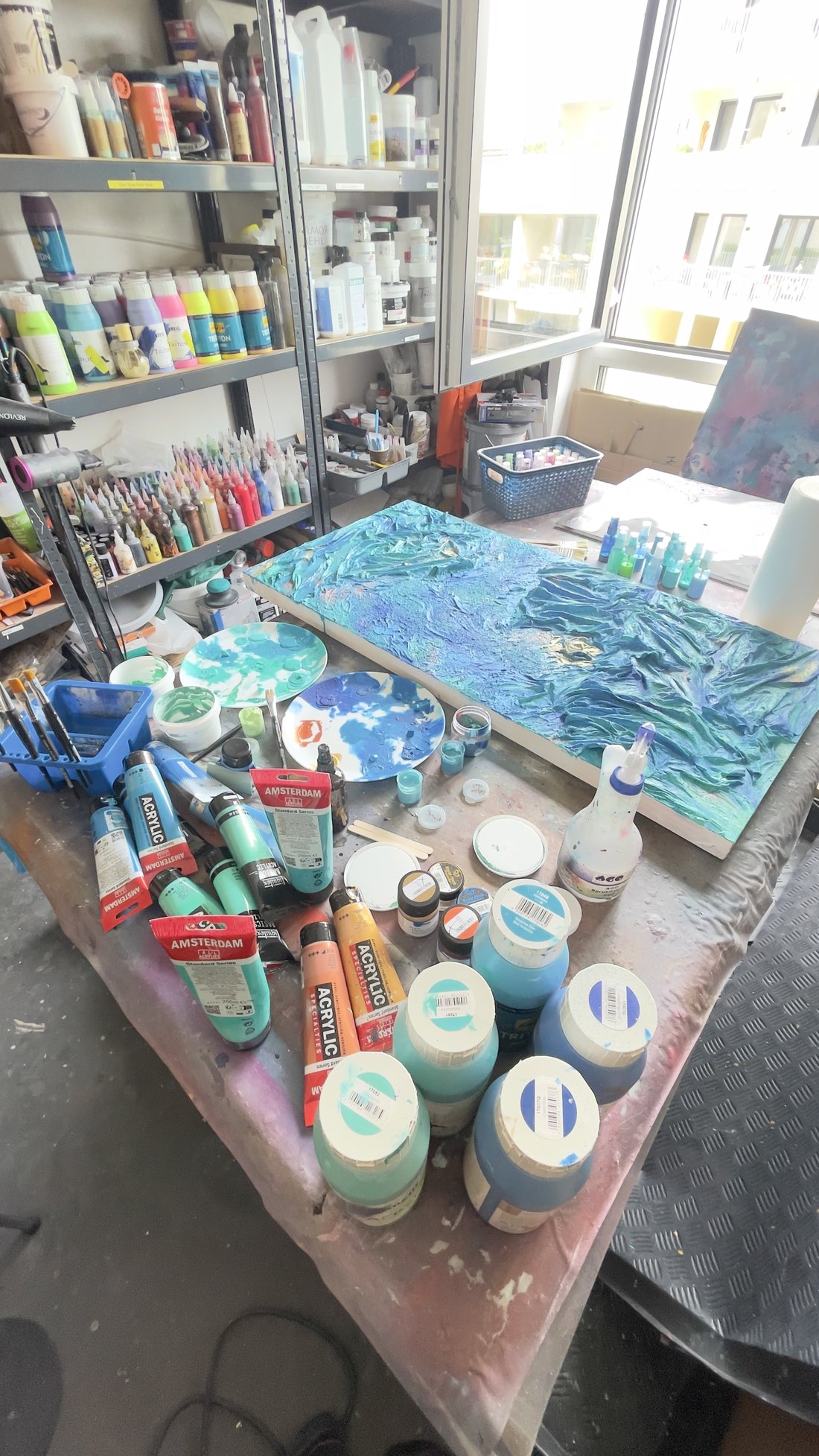 Das Atelier von Sonja Pelkowski mit Farben, Werkzeugen und Werk in Arbeit